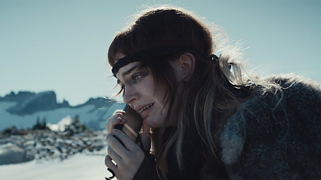 Natalie uses a satellite phone on a snowy ridge in the Yellowjackets Season 3 finale.