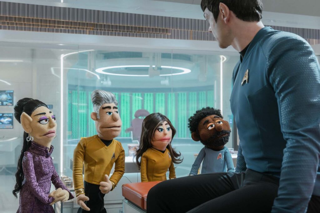 The puppet versions of T'Pring (Gia Sandhu), Capt. Pike (Anson Mount), Una (Rebecca Romijn), Dr. M’Benga (Babs Olusanmokun) confer with Spock (Ethan Peck) in Season 4, Episode 5 of Star Trek: Strange New Worlds.